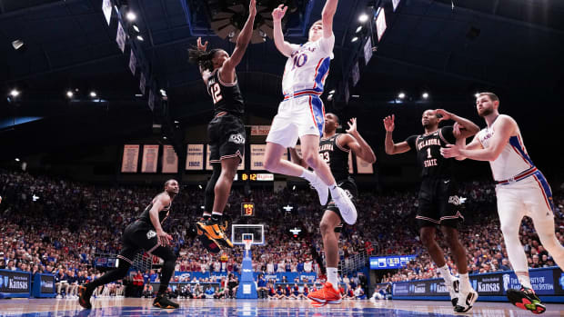 Jan 30, 2024; Lawrence, Kansas, USA; Kansas Jayhawks guard Johnny Furphy (10) shoots as Oklahoma State Cowboys guard Javon Small (12) defends during the first half at Allen Fieldhouse. Mandatory Credit: Denny Medley-USA TODAY Sports
